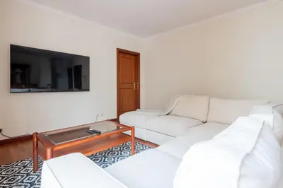 a living room with white furniture and a flat screen tv at Madeira Sunny Penthouse in Funchal