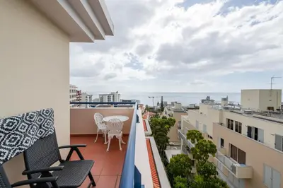 a balcony with chairs and a view of the ocean at Madeira Sunny Penthouse in Funchal