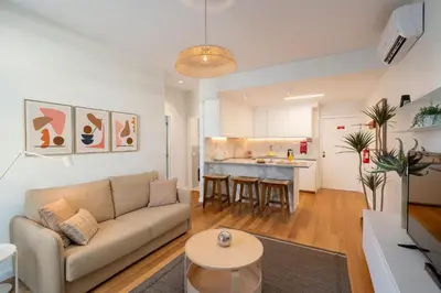 a living room with a couch and a kitchen at Infante Funchal Centrum in Funchal