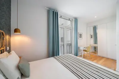 a bedroom with a bed and a window and a desk at Infante Funchal Centrum in Funchal