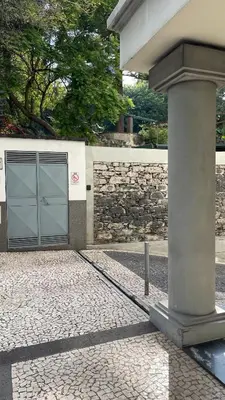 a building with a garage with a stone wall at Infante Funchal Centrum in Funchal