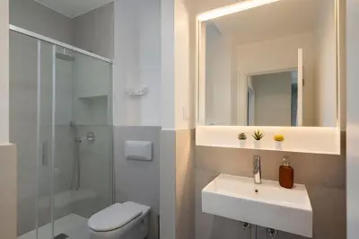 a bathroom with a sink and a toilet and a mirror at Infante Funchal Centrum in Funchal