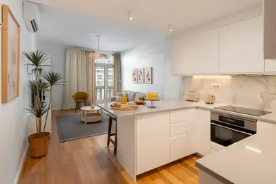 a kitchen with white cabinets and a table in it at Infante Funchal Centrum in Funchal