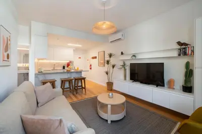 a living room with a couch and a tv and a kitchen at Infante Funchal Centrum in Funchal