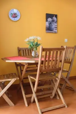 a dining room table with two chairs and a vase of flowers at Gabriel Loft by MTH in Ponta do Sol