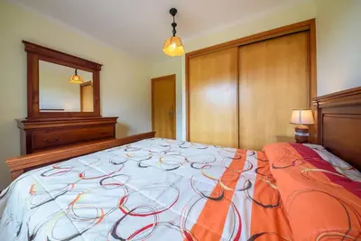 a bedroom with a large bed with an orange blanket at Gabriel Loft by MTH in Ponta do Sol