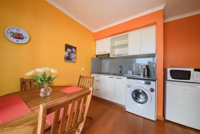 a kitchen with a table and a washing machine at Gabriel Loft by MTH in Ponta do Sol