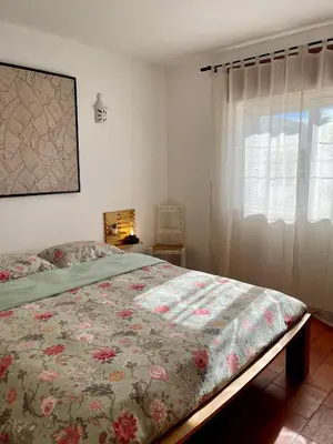 a bedroom with a bed with a floral bedspread at Casa Luz in Luz