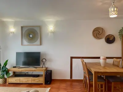 a living room with a television and a dining room table at Casa Luz in Luz