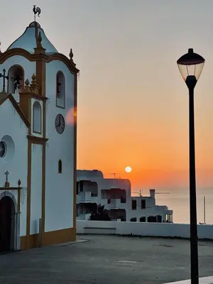 a clock tower and a street light in front of the ocean at Casa Luz in Luz