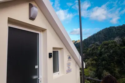 a building with a black garage door with mountains in the background at GuestReady - Delight Getaway in Madeira in Machico