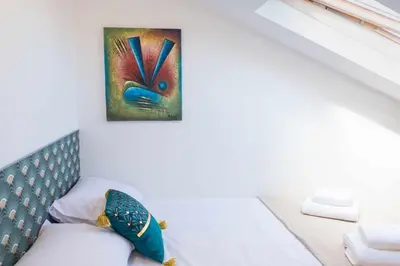 a room with a bed with a painting on the wall at Rosalina's Apartment in Caniço