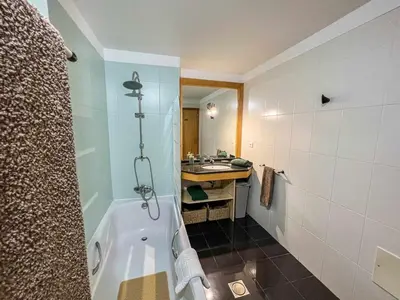 a bathroom with a bath tub and a sink at Rosalina's Apartment in Caniço