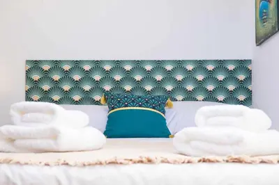 a bed with a headboard with two white towels on it at Rosalina's Apartment in Caniço