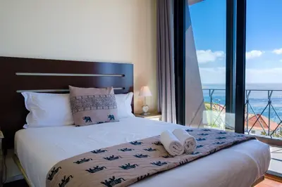 a bedroom with a bed with a view of the ocean at GuestReady - Funchal Sunny Retreat in Funchal