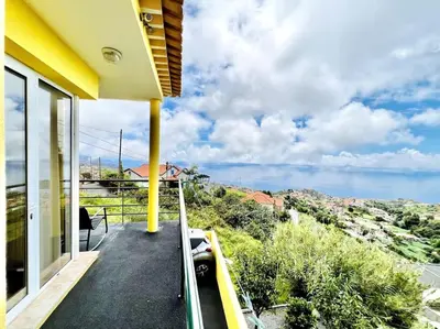 a bedroom with a bed and a flat screen tv at Casa Amarela by Your Madeira Rentals in Ponta do Sol