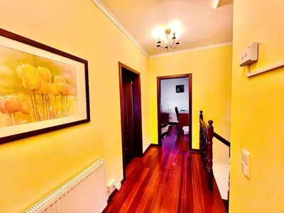 a hallway with a painting of flowers on the wall at Casa Amarela by Your Madeira Rentals in Ponta do Sol