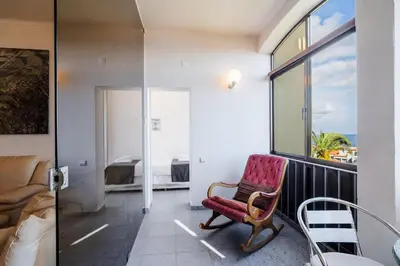 a bedroom with a bed and a table and chairs at GuestReady - A beautiful sight over the sea in Caniço