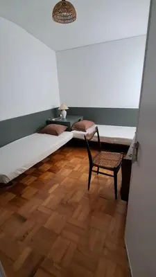 a room with two beds and a chair in it at Casa da Avó Teresa in Porto Santo