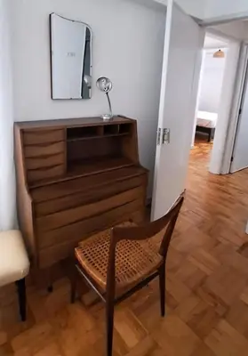 a chair and a dresser in a room with a mirror at Casa da Avó Teresa in Porto Santo