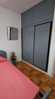a bedroom with a red bed and a large window at Casa da Avó Teresa in Porto Santo