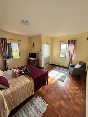 a bedroom with a bed and a couch and a chair at El Atardecer del Norte in Salão