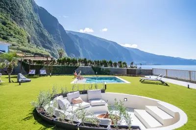 a resort with a pool and a grassy yard at Hilani House by Homie in São Vicente