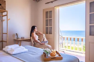 a woman sitting in a chair in a room with a window at Hilani House by Homie in São Vicente