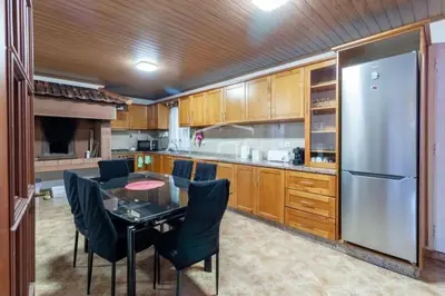 a kitchen with a table and a stainless steel refrigerator at Peaceful retreat near Levadas in Arco da Calheta