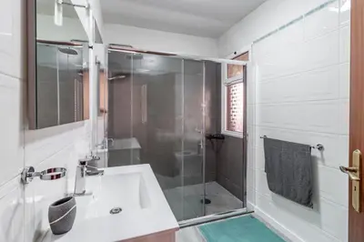 a white bathroom with a shower and a sink at Peaceful retreat near Levadas in Arco da Calheta