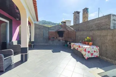 a patio with a table and a fireplace on a building at Peaceful retreat near Levadas in Arco da Calheta