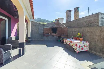 a patio with a table and a fireplace on a building at Peaceful retreat near Levadas in Arco da Calheta