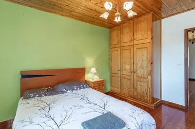 a bedroom with a bed and a wooden cabinet at Casa Central - Peceful Mountain Retreat in Calheta in Arco da Calheta