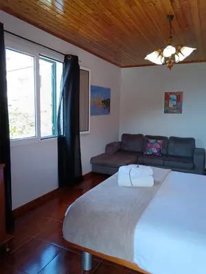 a bedroom with a large bed and a couch at Casa Central - Peceful Mountain Retreat in Calheta in Arco da Calheta