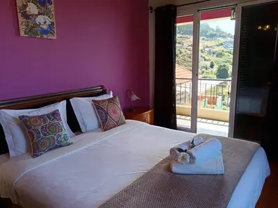 a bedroom with a white bed with a white purse on it at Casa Central - Peceful Mountain Retreat in Calheta in Arco da Calheta