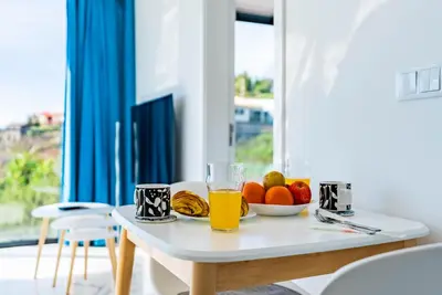 a table with a bowl of fruit and a glass of orange juice at Casa Branca-A, beautiful sea view in Estreito da Calheta