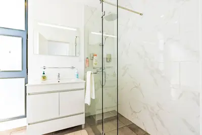 a white bathroom with a shower and a sink at Casa Branca-A, beautiful sea view in Estreito da Calheta