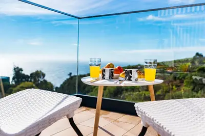 a table with a tray of food and glasses of orange juice at Casa Branca-A, beautiful sea view in Estreito da Calheta