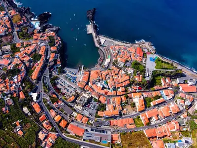 an aerial view of a city next to the water at Enchanted Bay in Câmara de Lobos