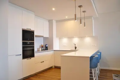 a kitchen with white cabinets and a counter top at Enchanted Bay in Câmara de Lobos