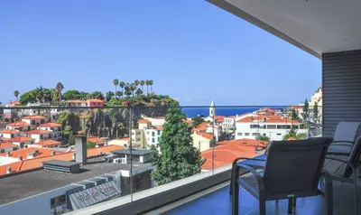 a balcony with a view of a city at Enchanted Bay in Câmara de Lobos