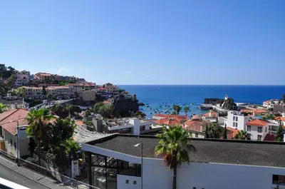 a view of a city and the ocean from a building at Enchanted Bay in Câmara de Lobos