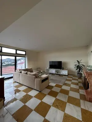 a large living room with a couch and a television at Funchal Casa 2 in Funchal