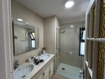 a bathroom with two sinks and a glass shower at Funchal Casa 2 in Funchal