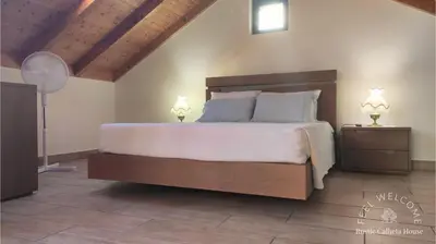 a bedroom with a large bed with two night stands at Rustic Calheta House in Arco da Calheta