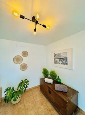 a living room with a ceiling fan and plants at Casa Juliana in Ribeira Brava