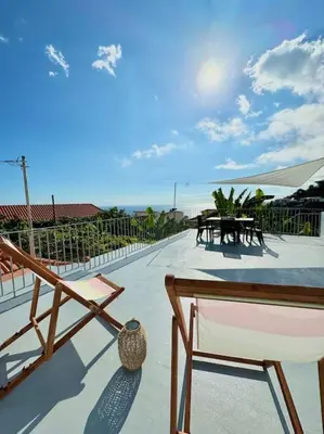 a patio with a table and chairs on a balcony at Casa Juliana in Ribeira Brava