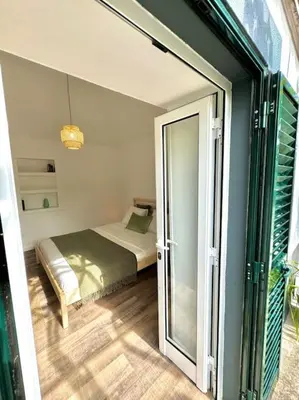 a bedroom with a bed and a sliding glass door at Casa Juliana in Ribeira Brava