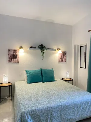a bedroom with a bed with blue pillows and two tables at Casa Bambi in Porto Santo