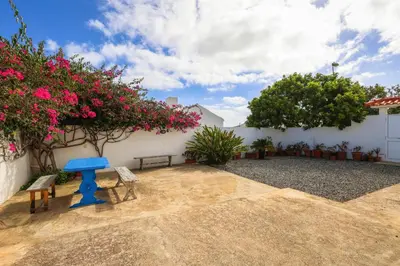 a patio with a blue table and benches and flowers at Casa Bambi in Porto Santo